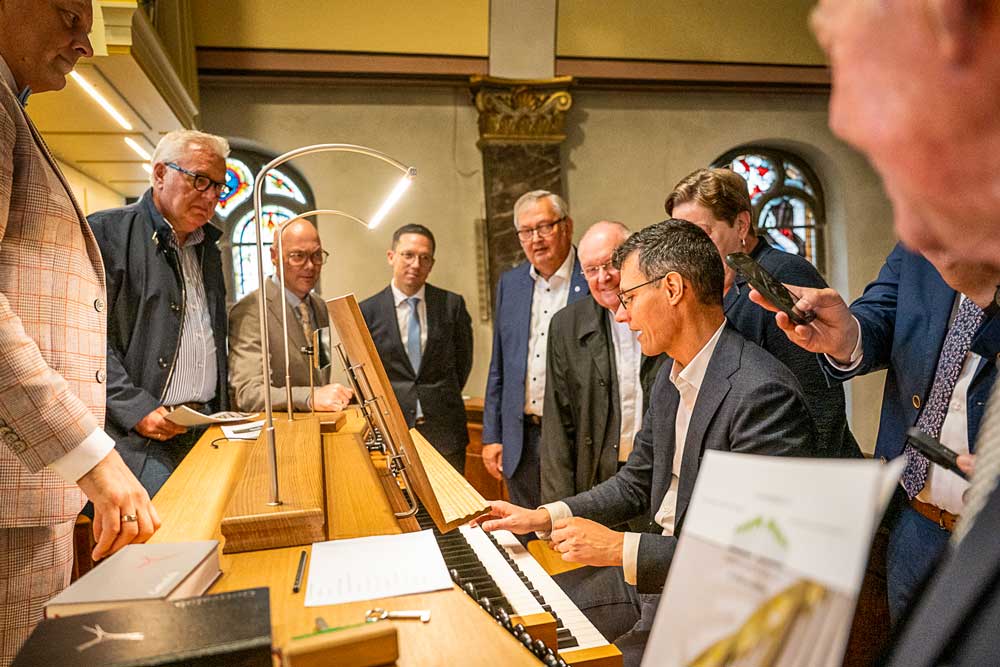 Organist Christian Kienel erklärt die neue Orgel im Kreis von Ehrengästen und Minister Falco Mohrs